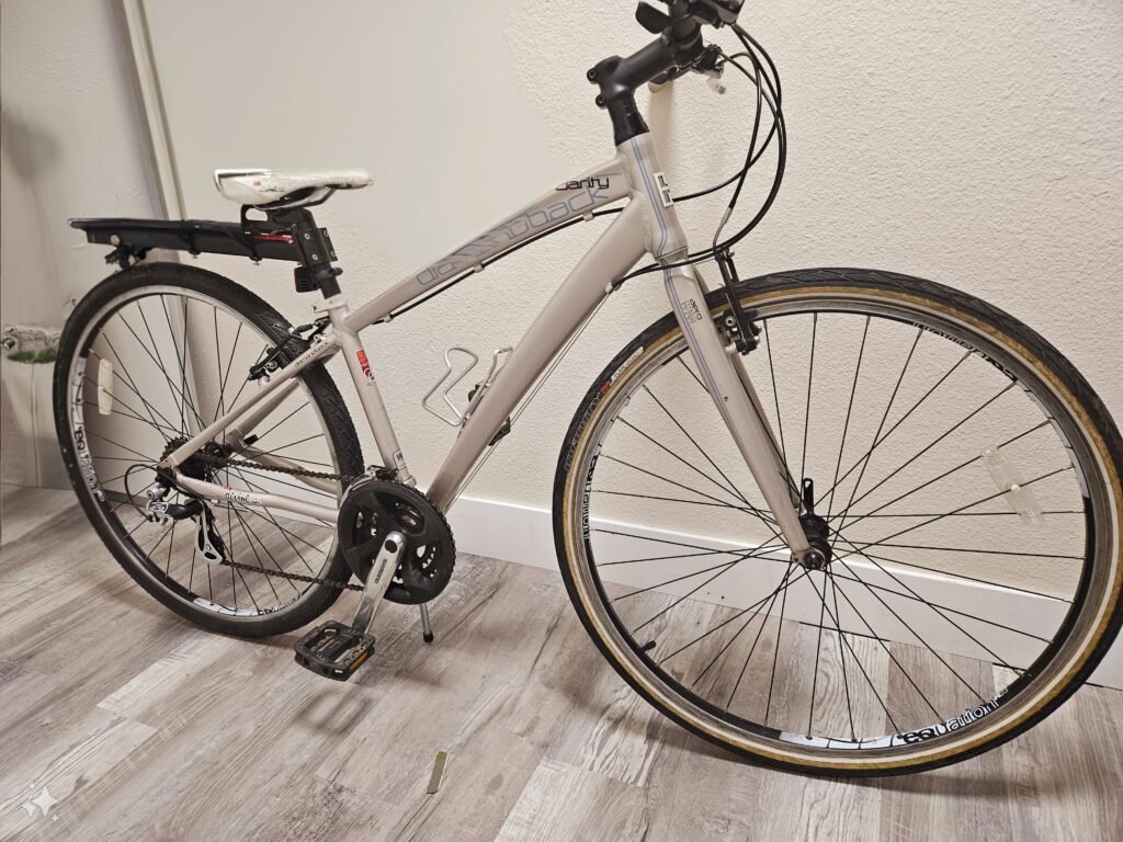 White road bike with a black rack.