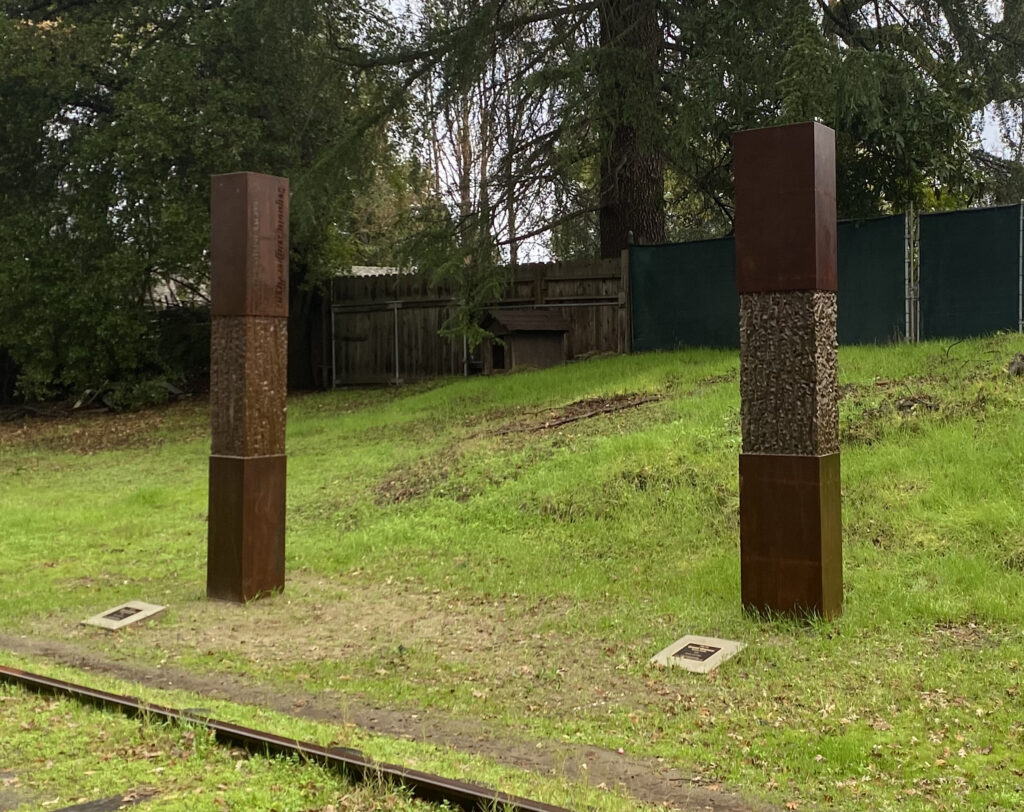 Two brown posts etched with a bark-like pattern.