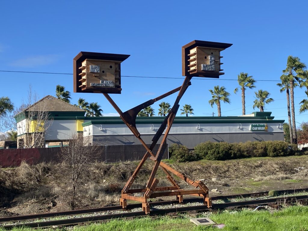 Two wooden boxes with metal designs on an iron structure.