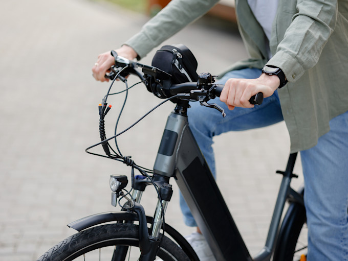 a person sits on an e-bike.